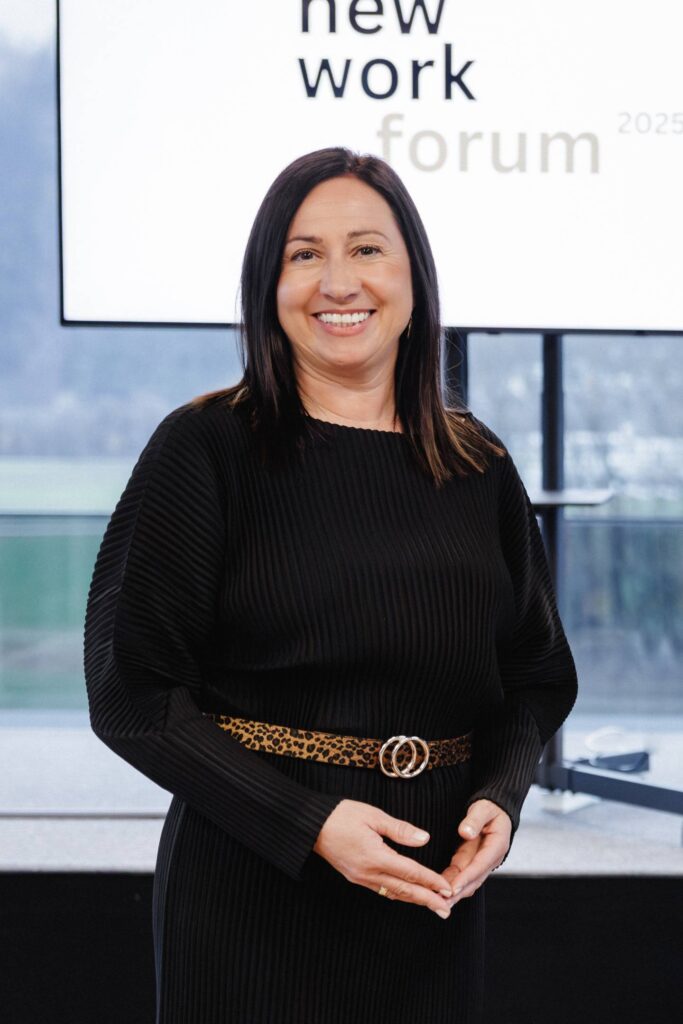 Barbara Schmidt Teamentwicklerin steht lächelnd vor einer Präsentationsfläche beim New Work Forum
