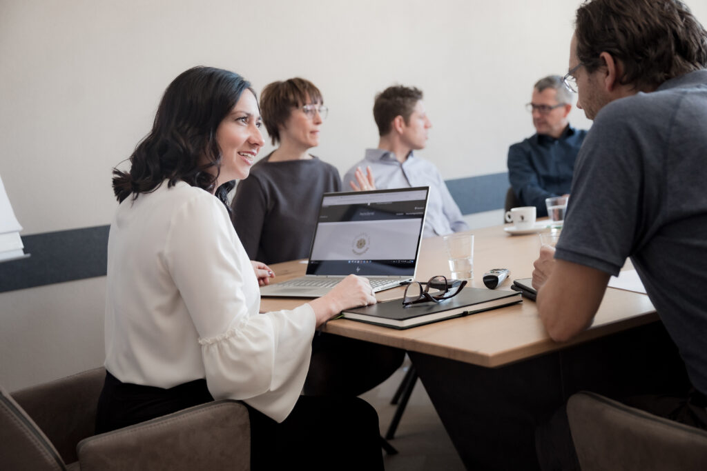 Professioneller Austausch in einem moderierten Workshop mit offener Gesprächsatmosphäre und Teamarbeit