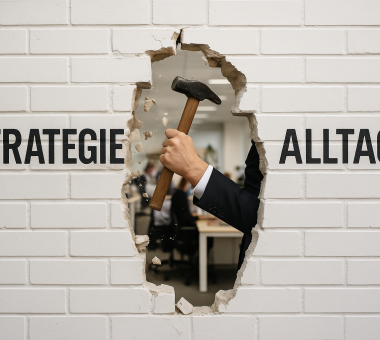 Weiße Wand mit den Worten „Strategie“ und „Alltag“ – ein Arm im Anzug durchbricht mit Hammer die Mauer zwischen beiden Bereichen